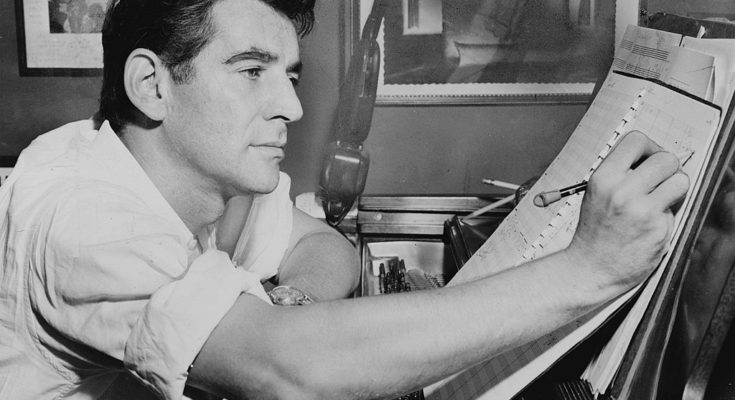 A photo of young Leonard Bernstein composing at a piano.