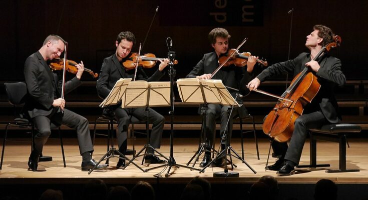 A photo of Quatuor Ébène performing on stage.