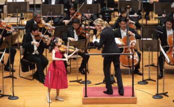 Violinist Himari performing with an orchestra.