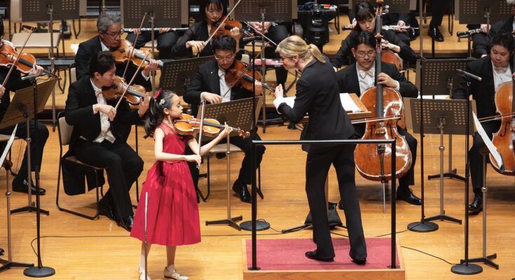 Violinist Himari performing with an orchestra.