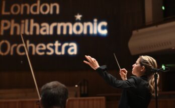 A photo of conductor Karina Canellakis leading the London Philharmonic.