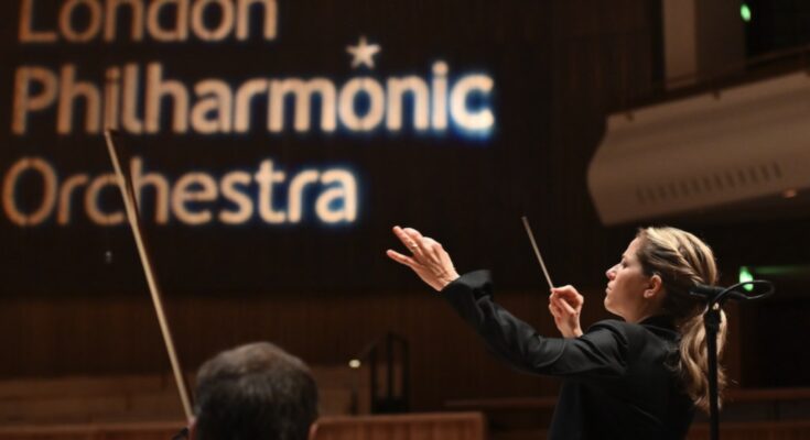 A photo of conductor Karina Canellakis leading the London Philharmonic.